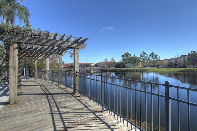 view of dock with a pergola and a water view