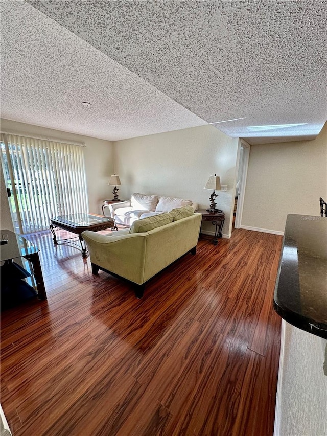 living room with a textured ceiling and dark hardwood / wood-style flooring