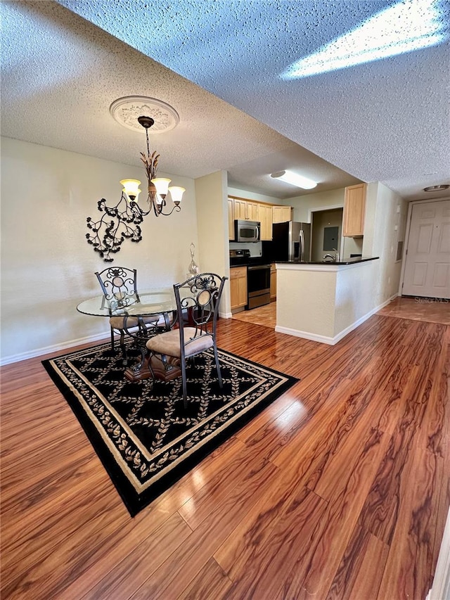 dining room featuring hardwood / wood-style flooring, a textured ceiling, and an inviting chandelier