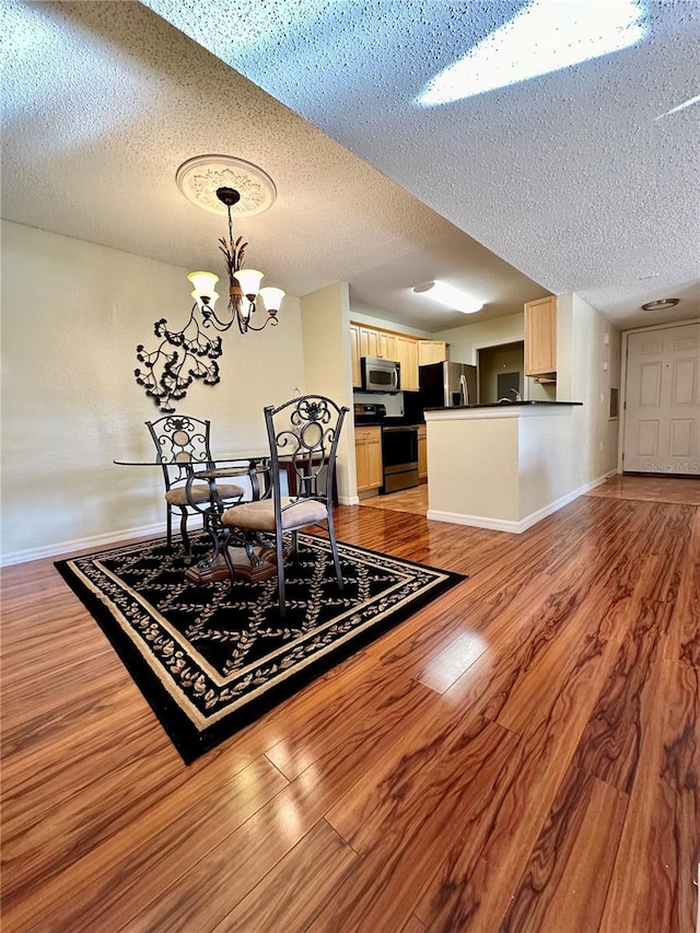 dining room featuring a textured ceiling, a chandelier, and hardwood / wood-style floors