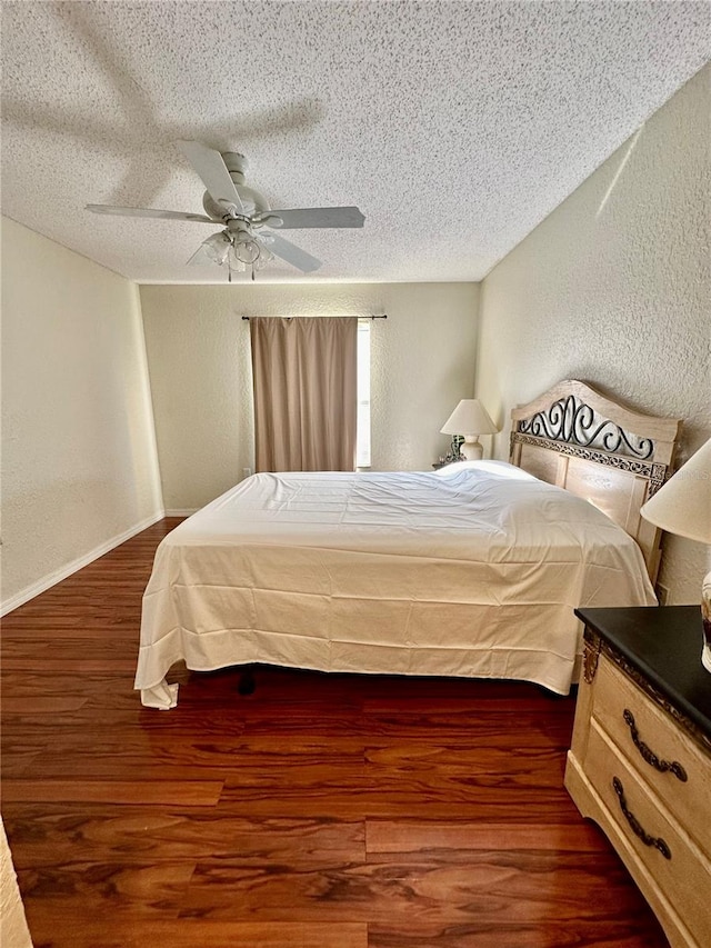 bedroom with ceiling fan, a textured ceiling, and dark hardwood / wood-style floors