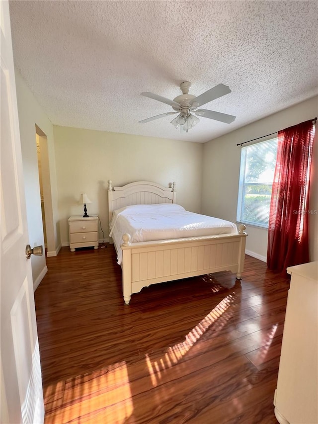 bedroom featuring ceiling fan, a textured ceiling, and dark hardwood / wood-style flooring