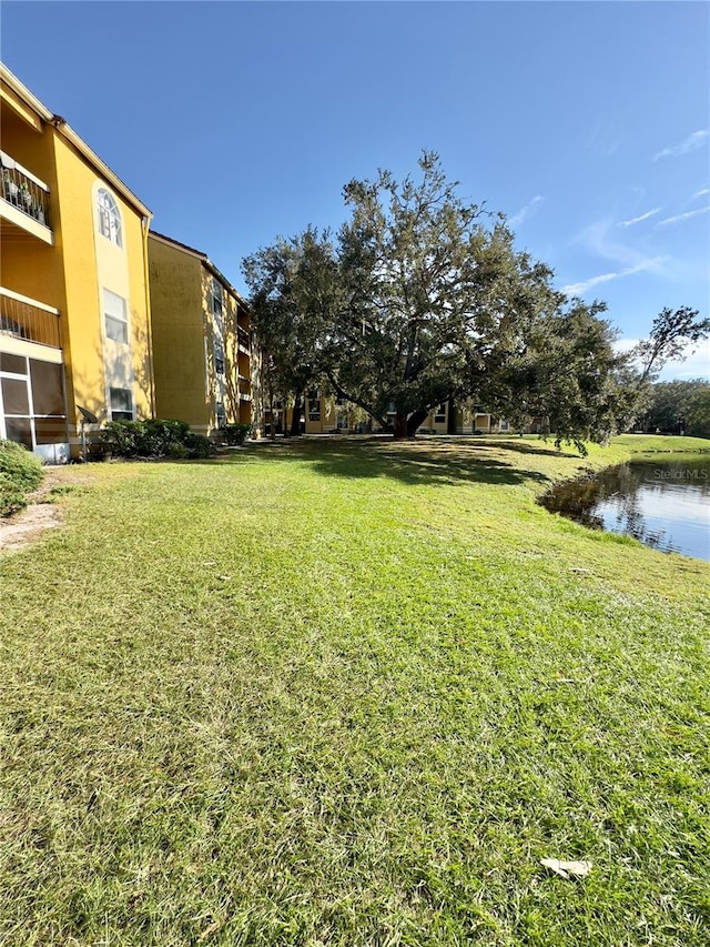 view of yard with a water view and a balcony