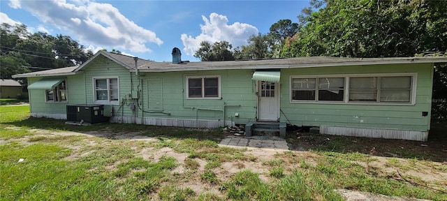 back of property featuring cooling unit and a lawn