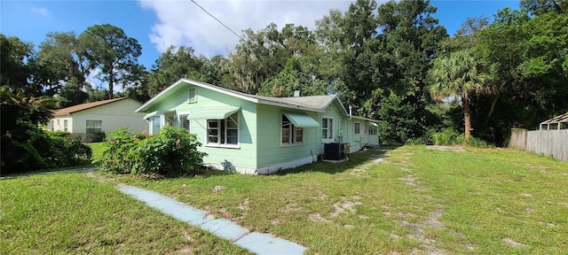 view of side of home featuring a lawn and cooling unit