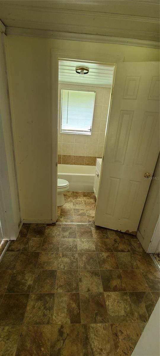 bathroom featuring vanity, a bath, and toilet