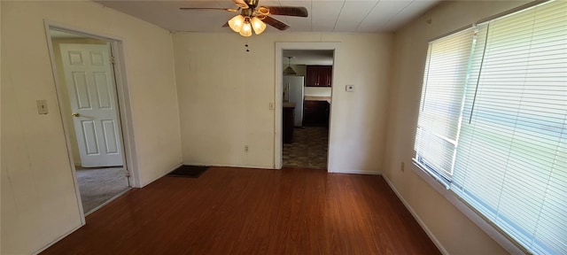 spare room featuring dark wood-type flooring and ceiling fan