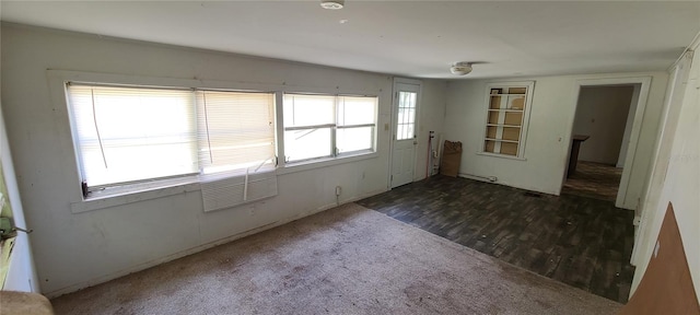 unfurnished room featuring dark wood-type flooring and a wealth of natural light