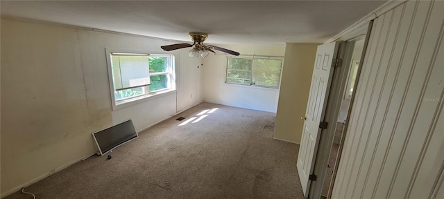 carpeted empty room with ceiling fan and crown molding