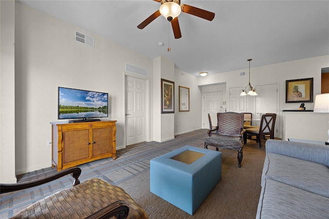 living room with ceiling fan with notable chandelier