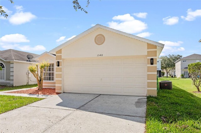 ranch-style home with a garage, a front lawn, and central AC unit