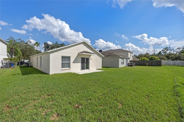 1548 Tiverton Blvd, Winter Garden, FL 34787 - back of property featuring a yard, stucco siding, central AC, and fence