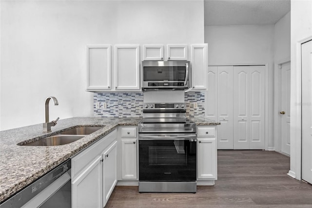 1548 Tiverton Blvd, Winter Garden, FL 34787 - kitchen featuring tasteful backsplash, white cabinetry, appliances with stainless steel finishes, wood finished floors, and a sink
