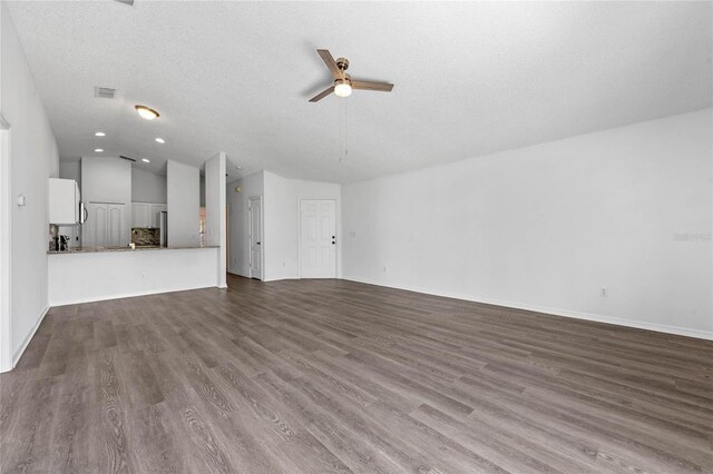 unfurnished living room featuring light wood-type flooring, lofted ceiling, ceiling fan, and a textured ceiling