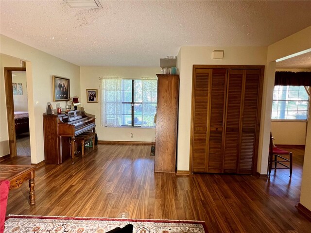 interior space featuring a textured ceiling and dark hardwood / wood-style flooring