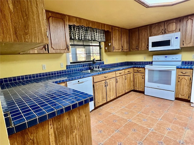 kitchen with sink, white appliances, tile countertops, and light tile patterned flooring