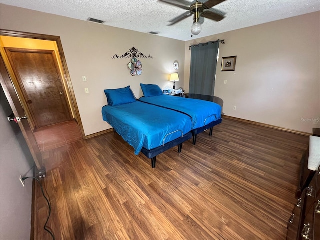 bedroom featuring ceiling fan, a textured ceiling, and dark hardwood / wood-style flooring