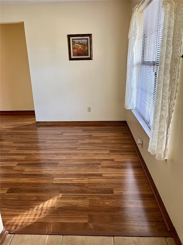 unfurnished room with dark hardwood / wood-style flooring