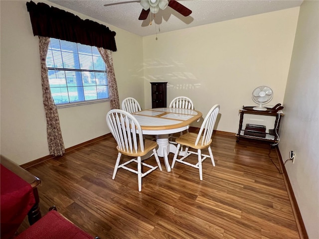 dining space with a textured ceiling, ceiling fan, and dark hardwood / wood-style flooring