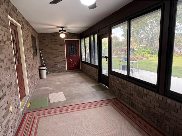 unfurnished sunroom with ceiling fan