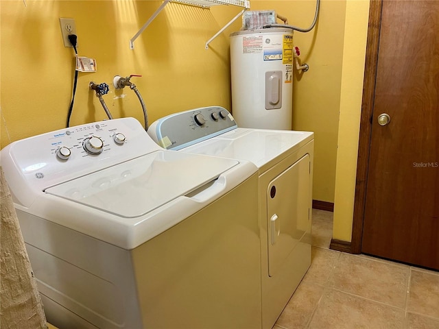 washroom with washer and dryer, light tile patterned floors, and water heater