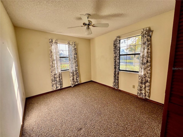 empty room featuring ceiling fan, carpet, and a textured ceiling