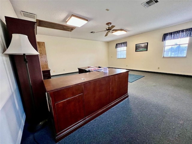 unfurnished office with ceiling fan, a textured ceiling, and a healthy amount of sunlight