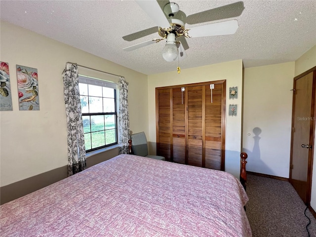 bedroom with ceiling fan, dark carpet, a textured ceiling, and a closet