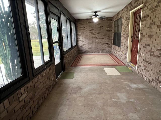 unfurnished sunroom with ceiling fan