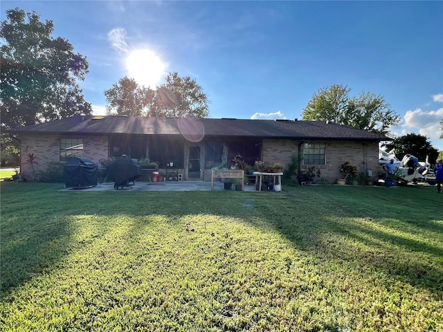 back of property featuring a patio area and a yard