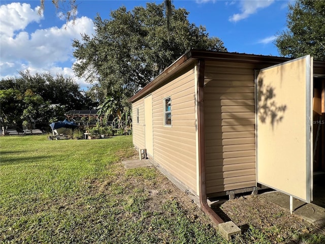 view of side of home featuring a shed and a lawn