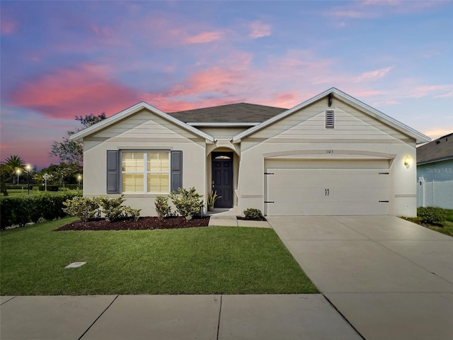 single story home featuring a garage and a yard