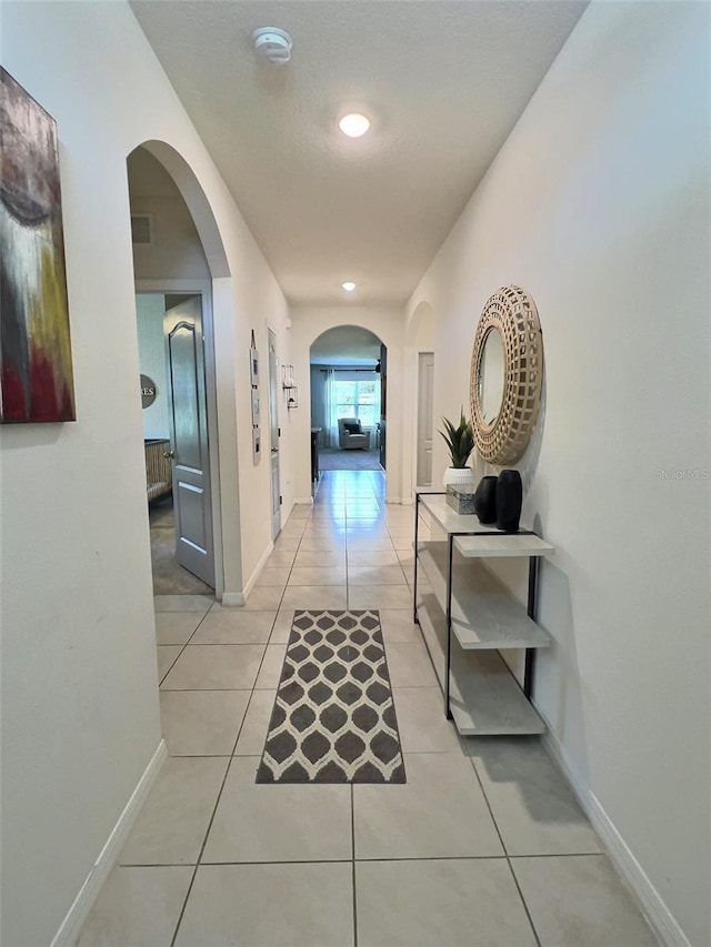 hall with light tile patterned floors