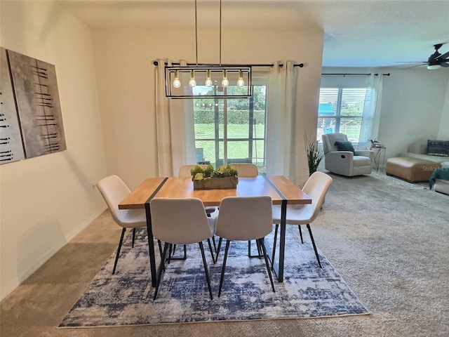 carpeted dining room featuring ceiling fan