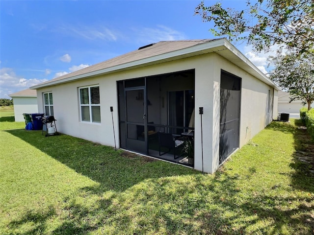 rear view of property featuring a sunroom and a yard