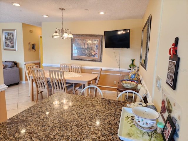 dining room with a notable chandelier, a textured ceiling, and light tile patterned floors