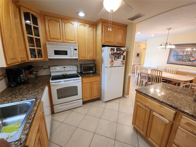 kitchen with light tile patterned flooring, sink, ceiling fan with notable chandelier, hanging light fixtures, and white appliances