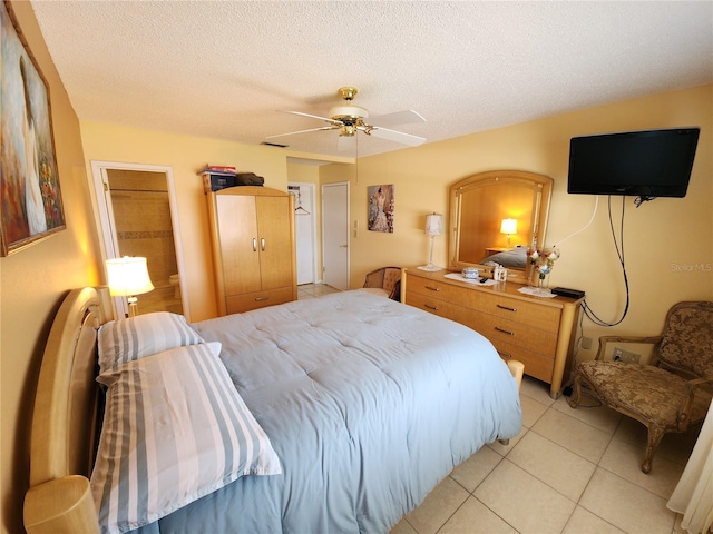 tiled bedroom featuring a textured ceiling and ceiling fan