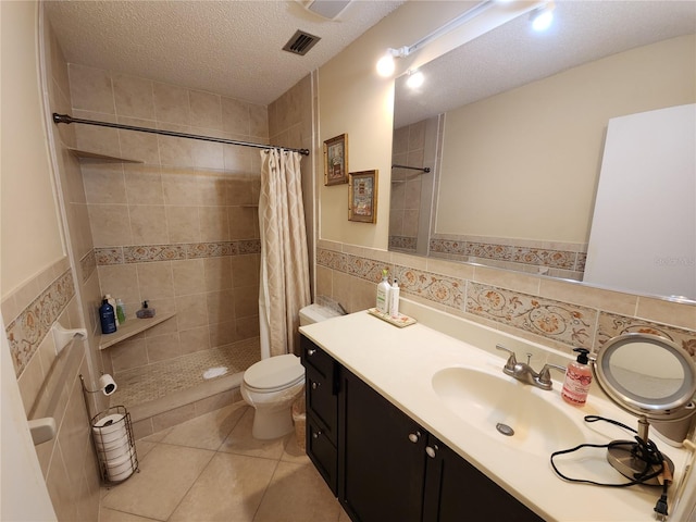 bathroom with tile walls, a textured ceiling, toilet, vanity, and curtained shower