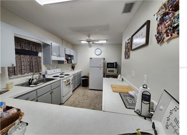 kitchen with ceiling fan, sink, white appliances, gray cabinetry, and a textured ceiling