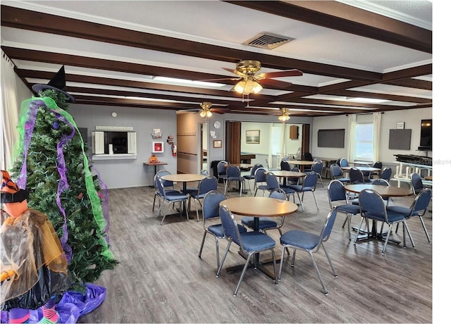 dining area featuring ceiling fan, hardwood / wood-style flooring, and beam ceiling