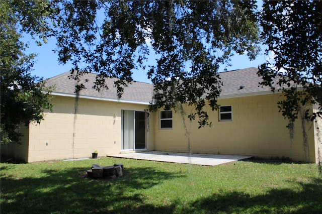 back of house with a patio area and a lawn