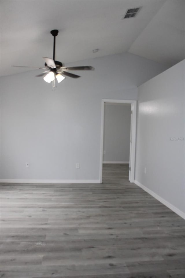 empty room featuring ceiling fan, vaulted ceiling, and hardwood / wood-style flooring