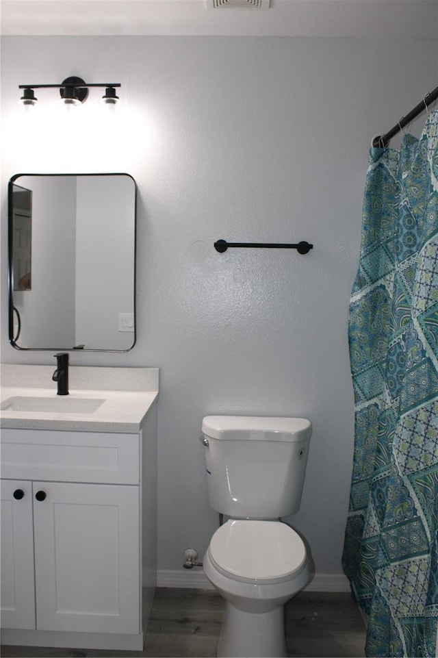 bathroom with hardwood / wood-style flooring, vanity, and toilet