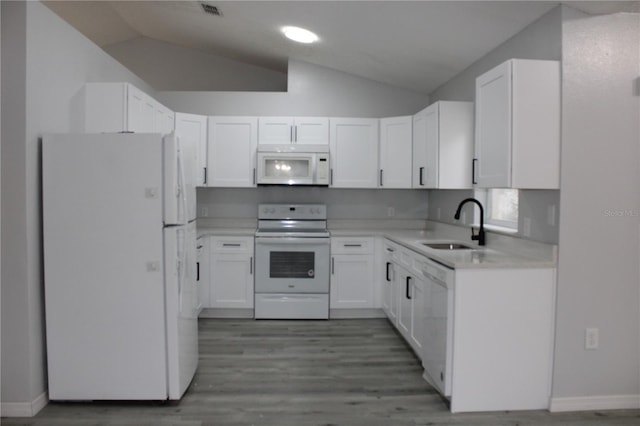 kitchen featuring white appliances, white cabinetry, vaulted ceiling, and sink