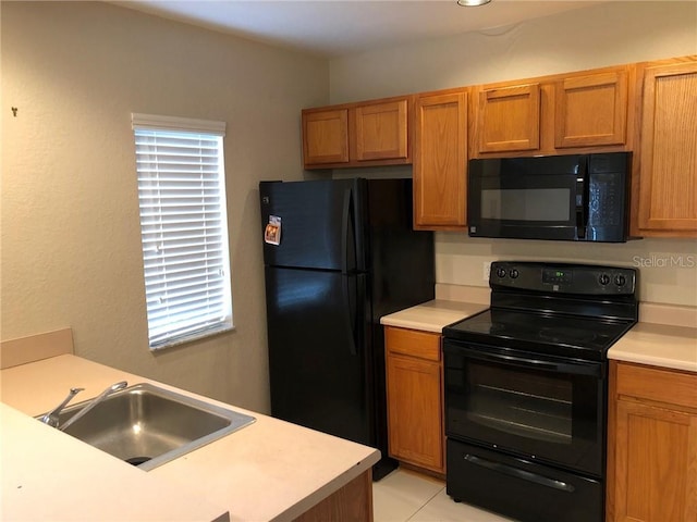 kitchen featuring light tile patterned flooring, sink, and black appliances