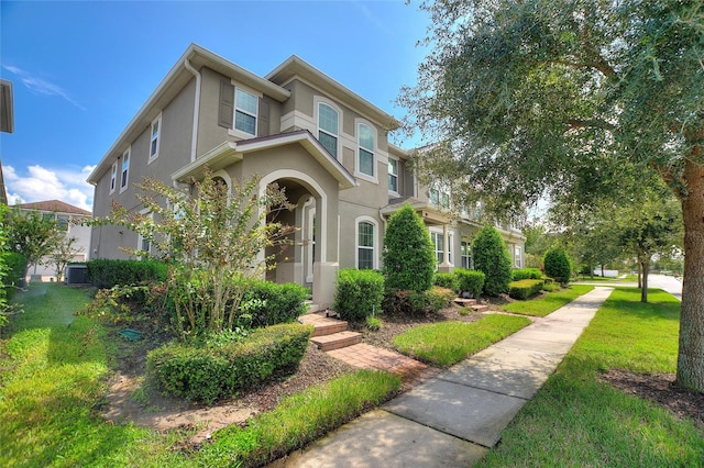 view of front of home featuring cooling unit and a front lawn