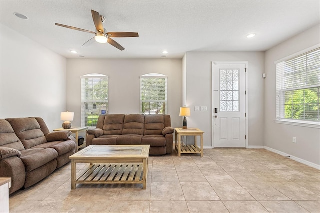 tiled living room with a textured ceiling and ceiling fan