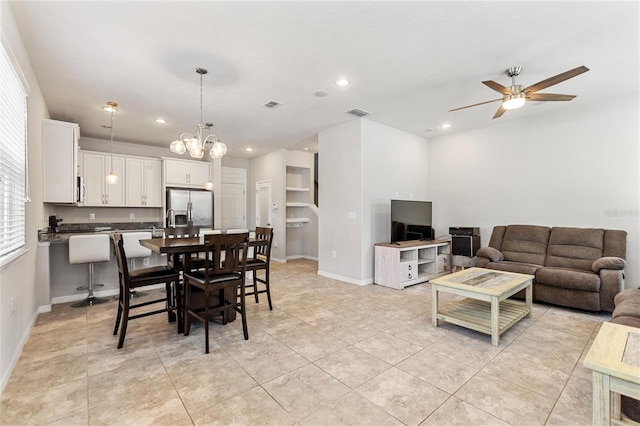 tiled dining space featuring ceiling fan with notable chandelier