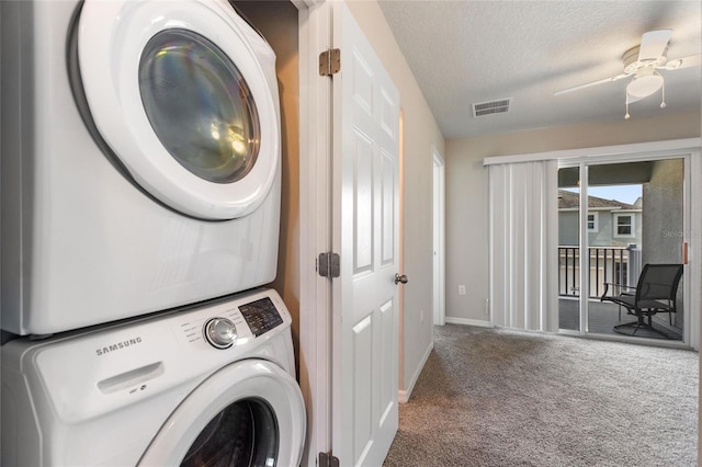 clothes washing area featuring ceiling fan, stacked washer / drying machine, carpet flooring, and a textured ceiling